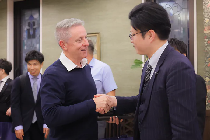 海外からの来訪者と握手を交わす参加者