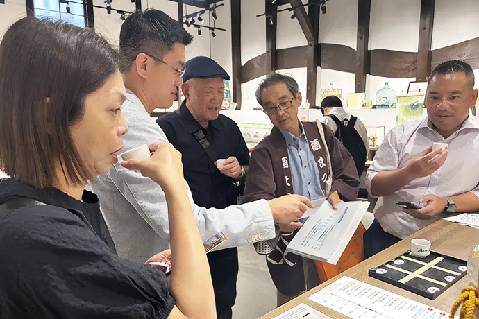 ショップ内で商品の説明を受ける見学参加者
