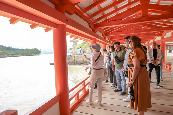神社の回廊から景色を眺めながら見学する参加者